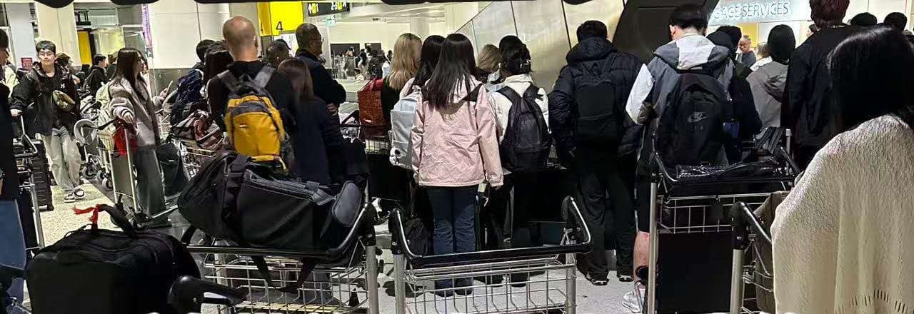 墨尔本机场到达大厅,旅客推着装满行李的手推车排队