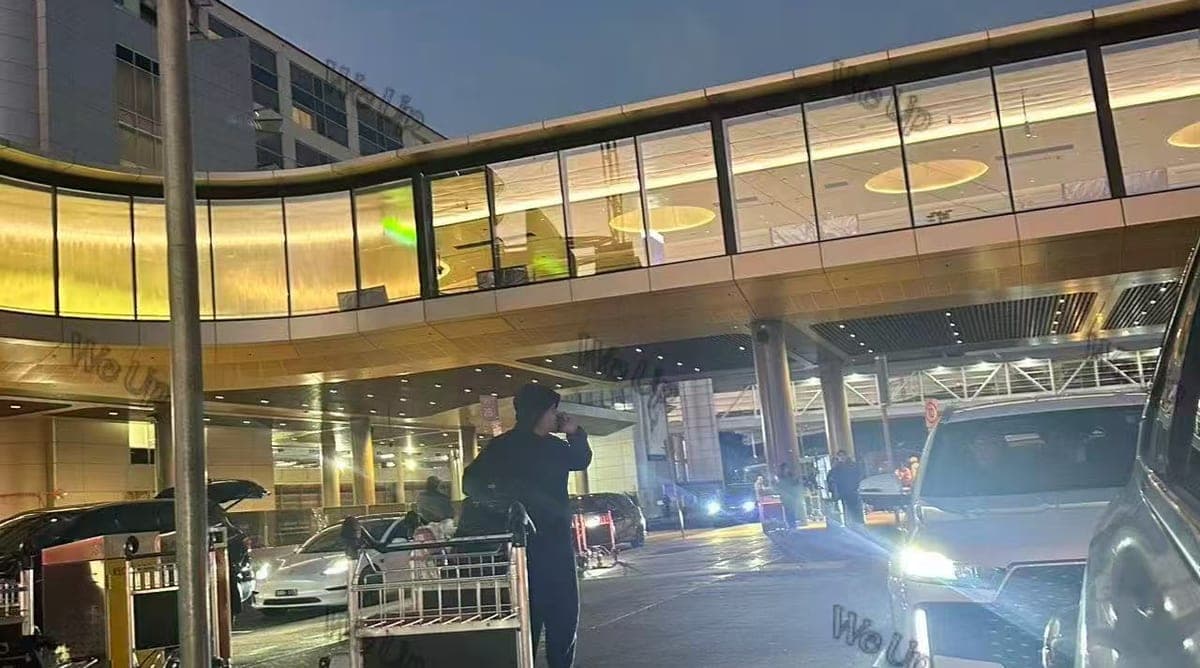 深夜的墨尔本机场到达层路边,一位旅客独自推着行李车